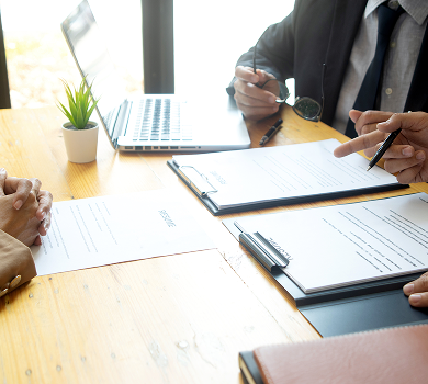 Professionals reviewing pricing documents at a meeting table