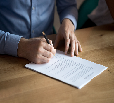 Hand signing a contract document with a pen